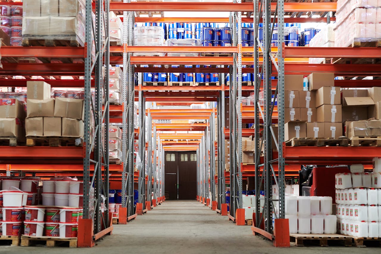 Home Wide angle view of a warehouse with stocked shelves and boxes.